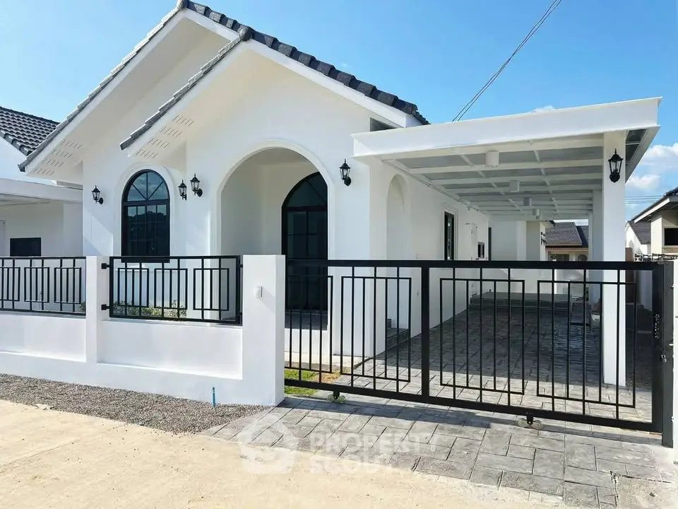 Charming modern white house with gated driveway and arched windows