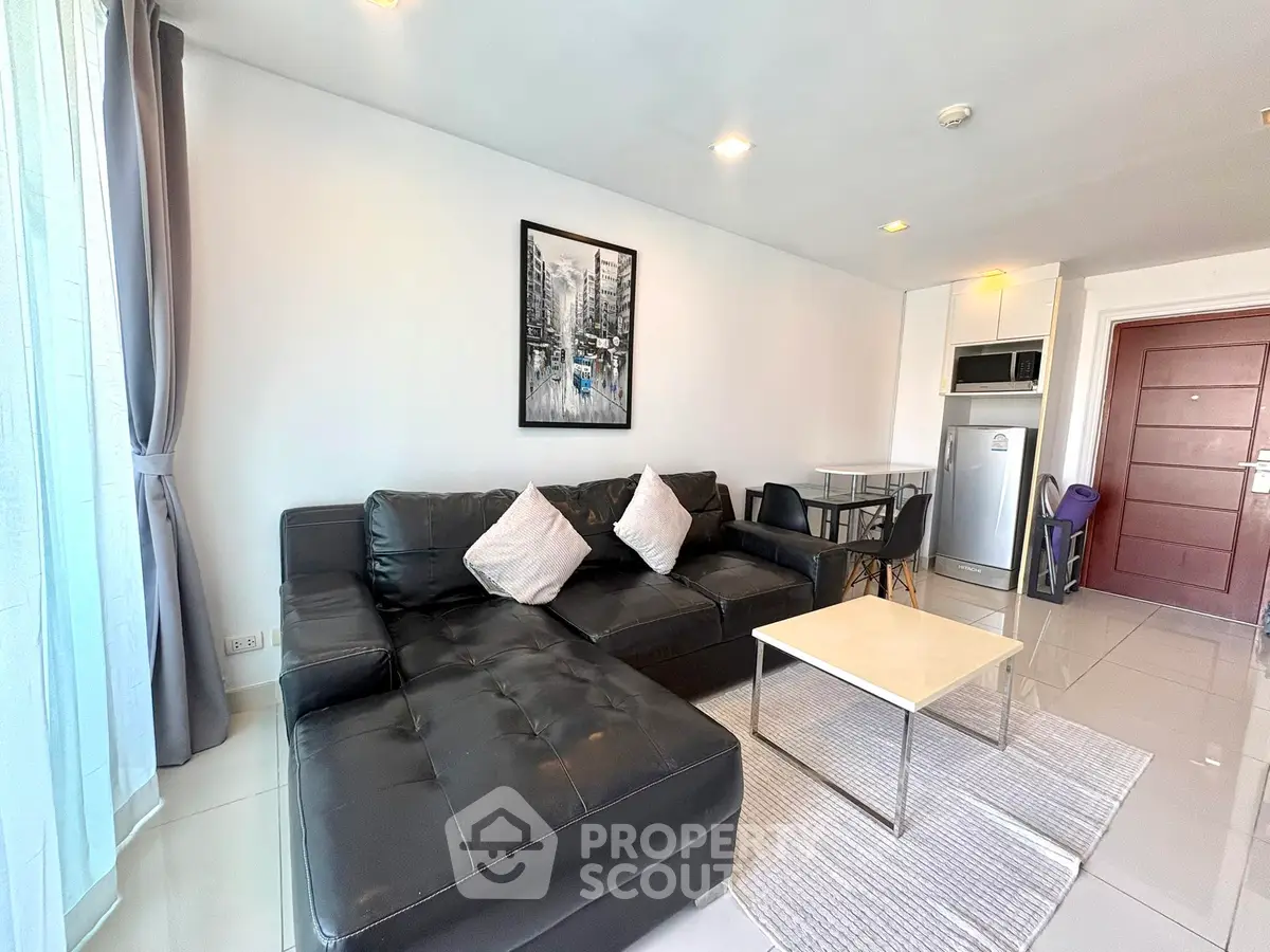 Modern living room with black leather sofa and stainless steel appliances