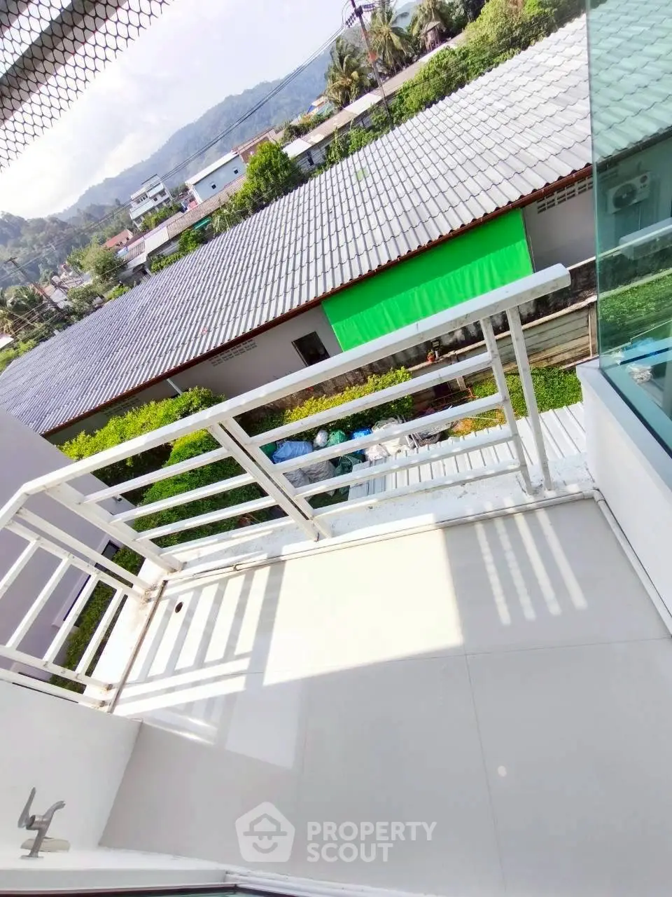 Charming balcony with scenic view of rooftops and lush greenery, perfect for relaxation and enjoying the outdoors.