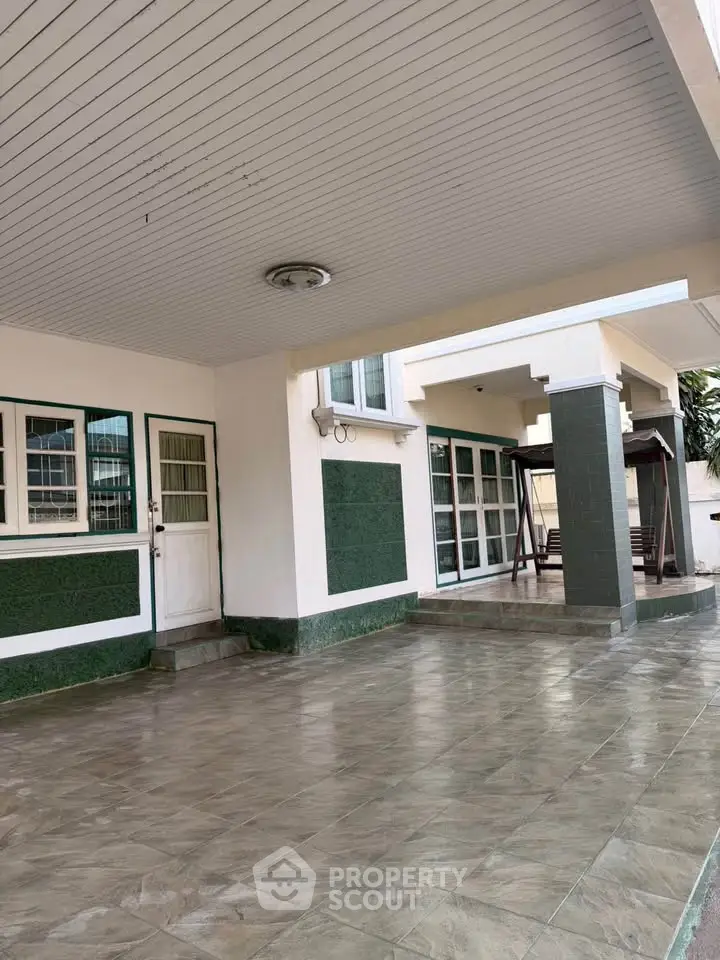 Spacious covered patio area with tiled flooring and modern design, perfect for outdoor gatherings.