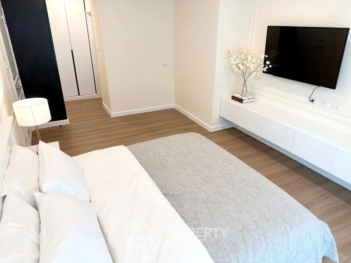 Modern bedroom with sleek design, wall-mounted TV, and elegant decor