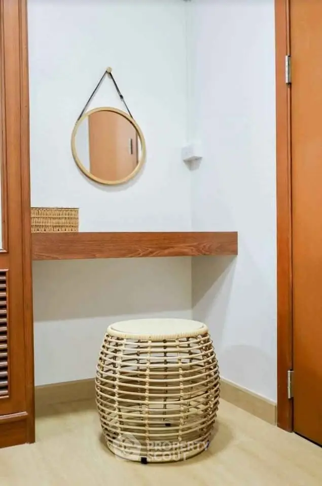 Cozy corner with wooden accents and a stylish wicker stool, perfect for a small home office or vanity area.