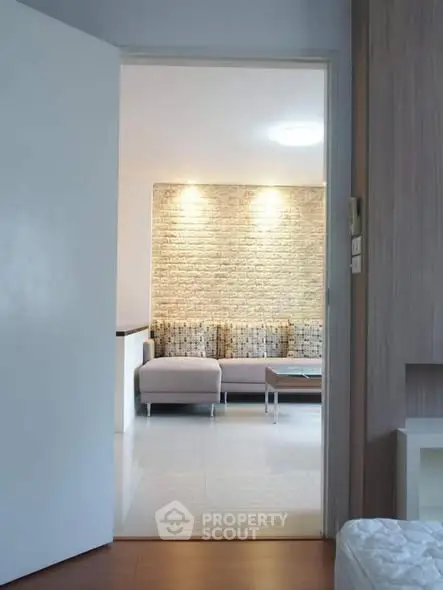 Modern living room with stylish brick accent wall and cozy seating area.