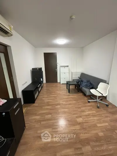 Spacious living room with modern furniture and wooden flooring, ideal for comfortable living.