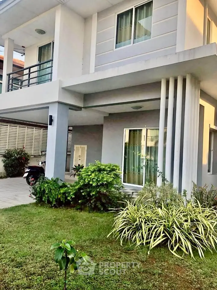Modern two-story house with lush garden and spacious driveway