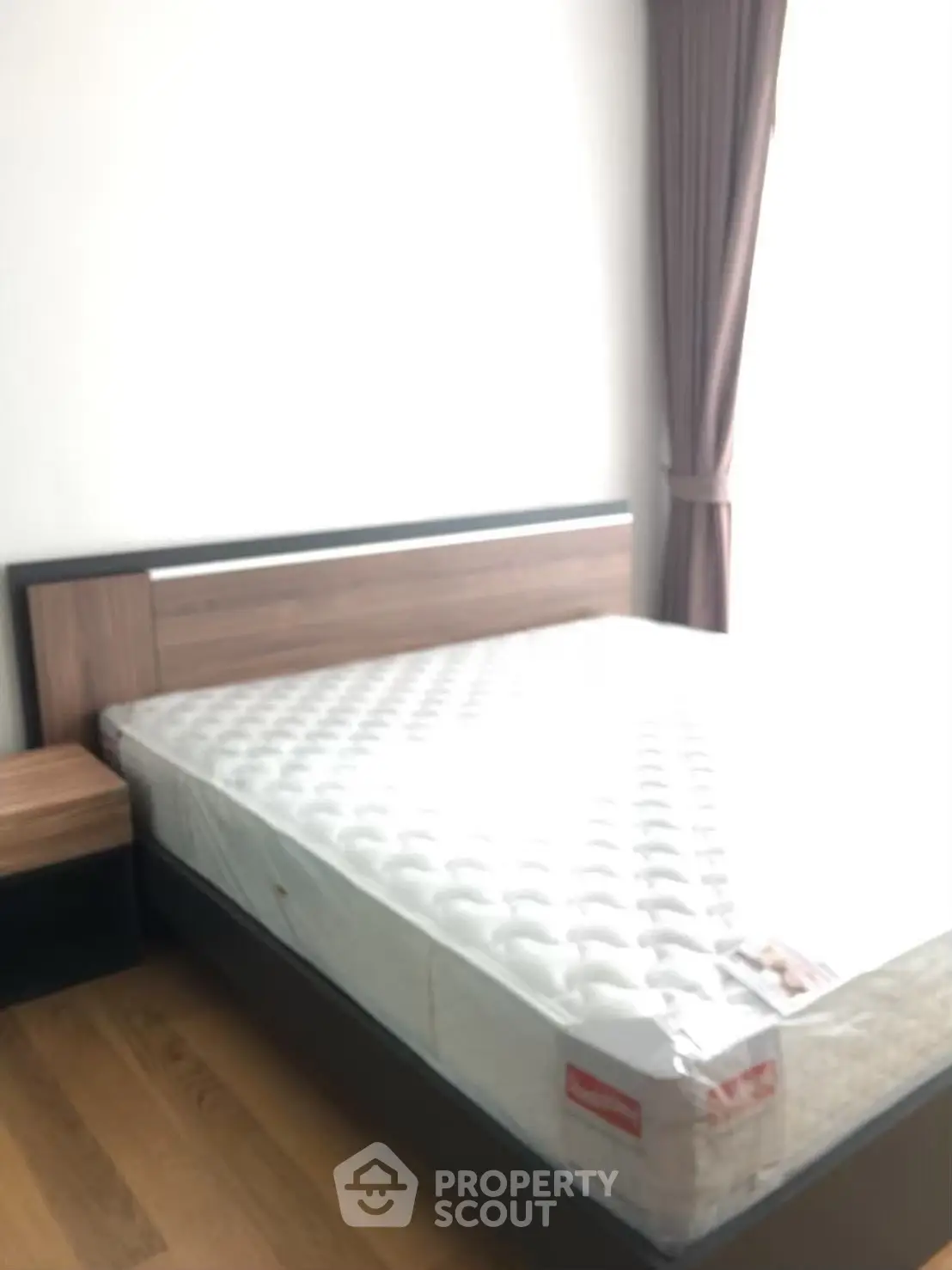 Spacious bedroom with modern wooden bed frame and natural light