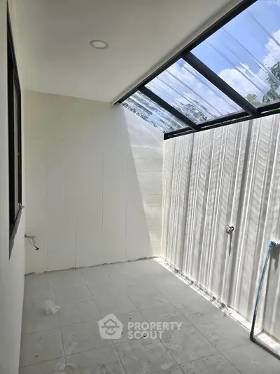 Bright and airy laundry area with skylight and tiled flooring, perfect for modern homes.