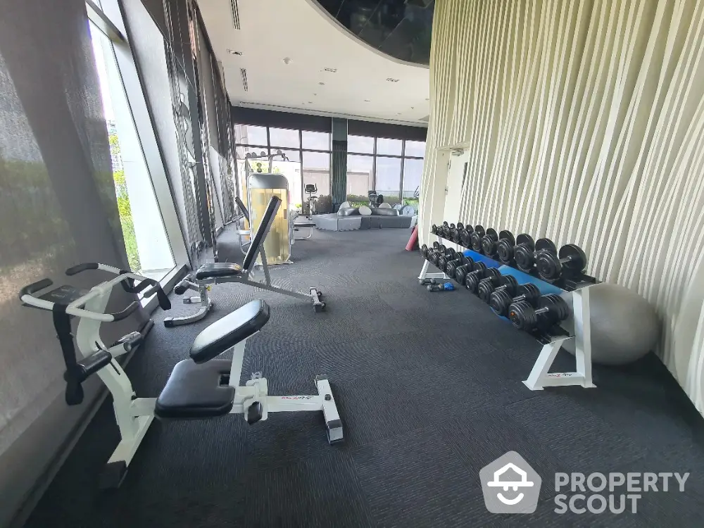 Modern gym with state-of-the-art equipment and panoramic windows in luxury real estate property.