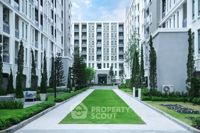 Elegant residential building with lush green courtyard and modern architecture.
