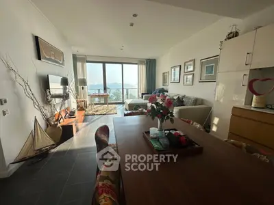 Spacious living room with ocean view, elegant decor, and abundant natural light.