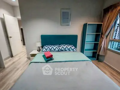 Cozy bedroom with modern decor and large window offering natural light