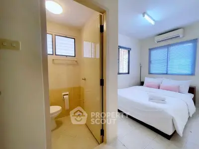 Cozy bedroom with ensuite bathroom, featuring modern amenities and natural light.