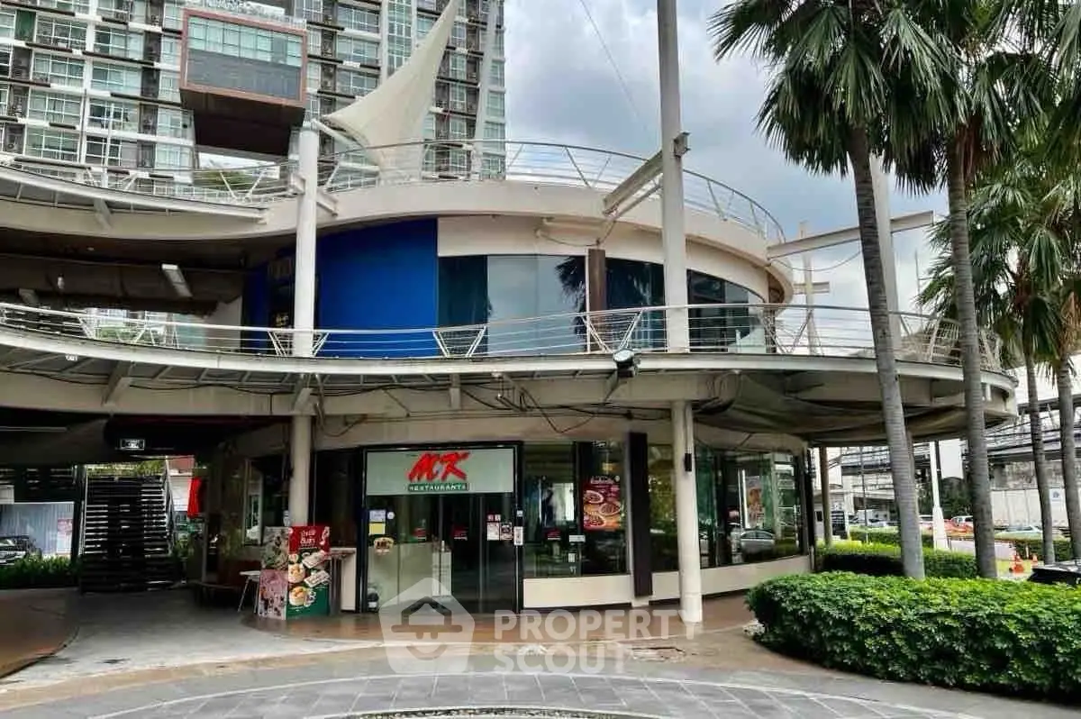 Modern commercial building exterior with lush greenery and unique architectural design.