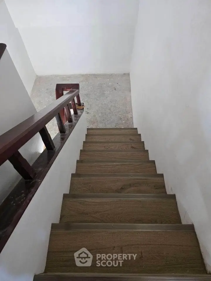 Modern wooden staircase with sleek railing in minimalist home interior