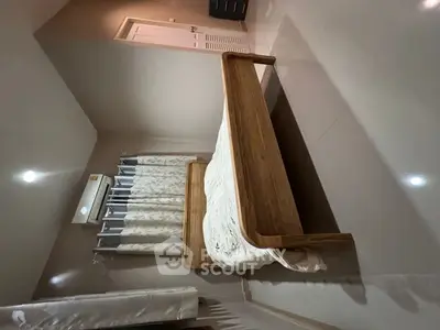 Cozy bedroom with wooden bed frame and elegant curtains, perfect for a restful retreat.