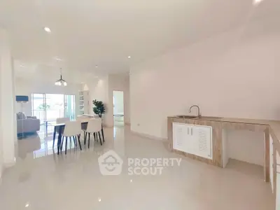 Spacious open-plan living and dining area with modern kitchen in bright apartment
