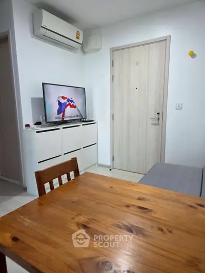 Cozy living room with wooden dining table and modern TV setup