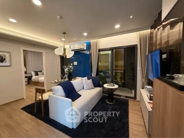 Modern living room with elegant decor and open layout, featuring a cozy sofa and stylish lighting.