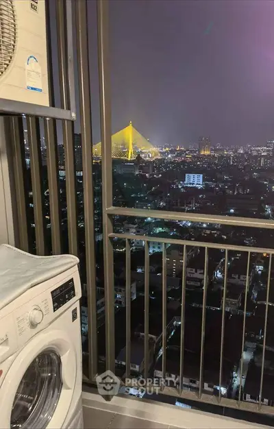 Stunning night city view from a high-rise balcony with washing machine.