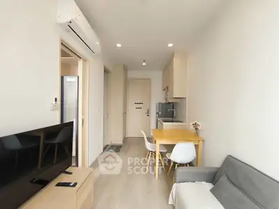 Modern compact living room with open kitchen and dining area, featuring sleek furniture and neutral tones.