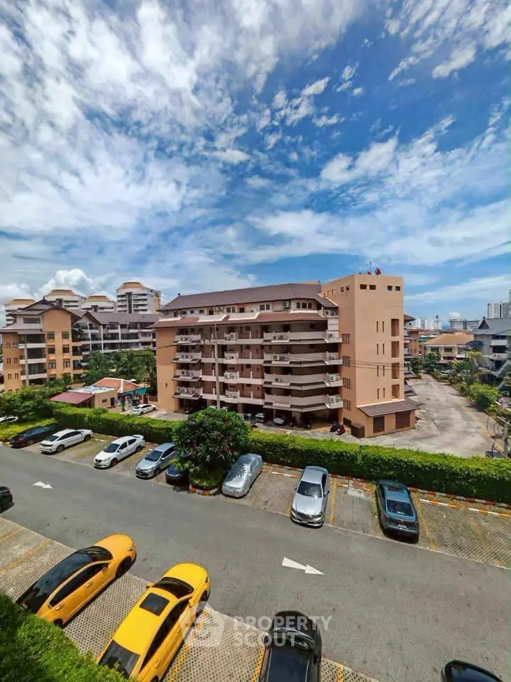 Stunning view of a residential building with ample parking and clear blue skies.