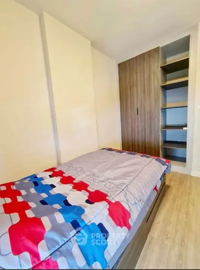 Modern bedroom with stylish wardrobe and colorful bedding in a cozy apartment.