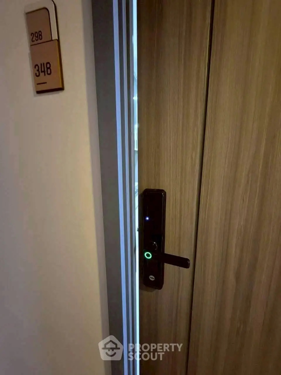 Modern apartment door with electronic lock and room number signage.