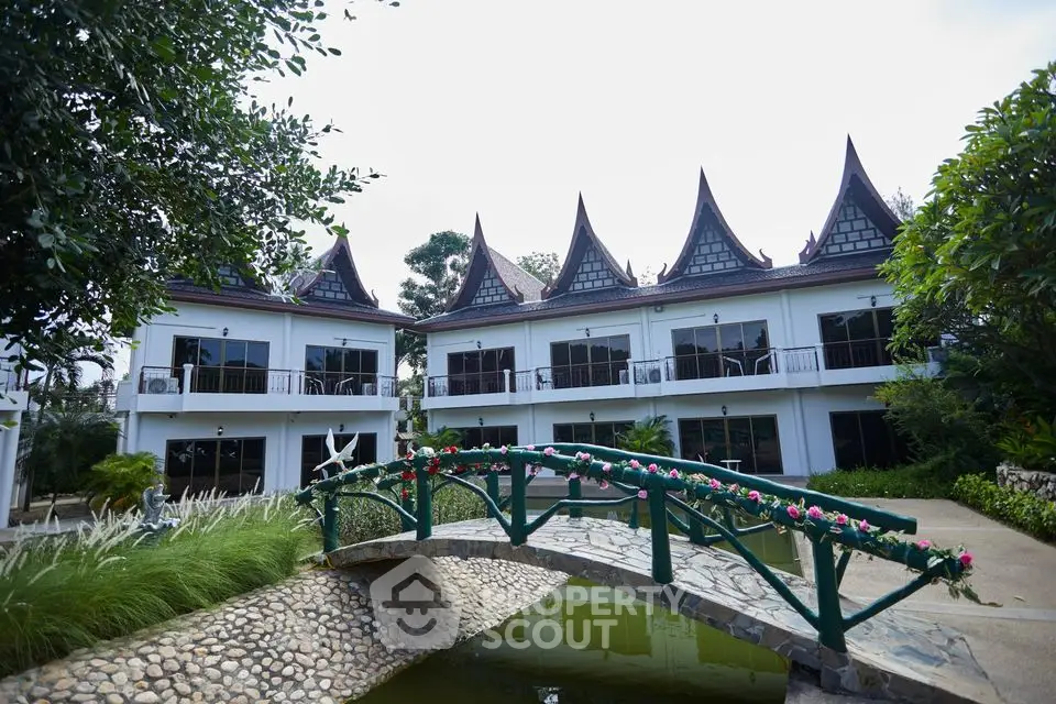 Charming Thai-style villa with unique roof design and serene garden bridge