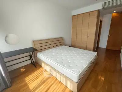 Spacious bedroom with wooden flooring and ample natural light