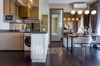 Modern open-plan kitchen and dining area with sleek design and elegant lighting.