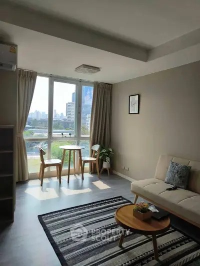 Bright living room with city view, modern furniture, and large window.