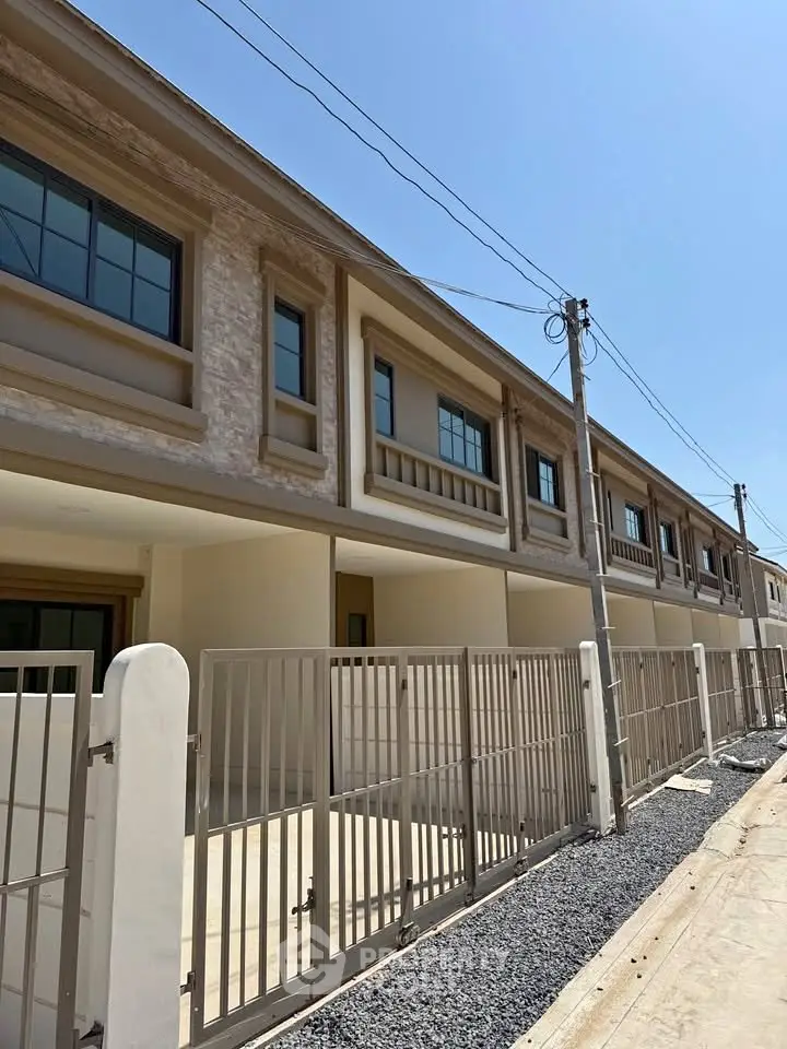 Modern townhouse exterior with gated entrance and clean architectural lines.