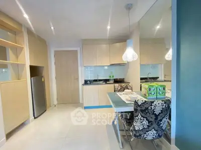 Modern kitchen with dining area, stylish lighting, and sleek cabinetry in a cozy apartment.