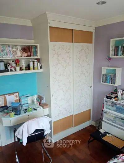 Charming bedroom with built-in wardrobe and cozy study nook, perfect for a comfortable living space.