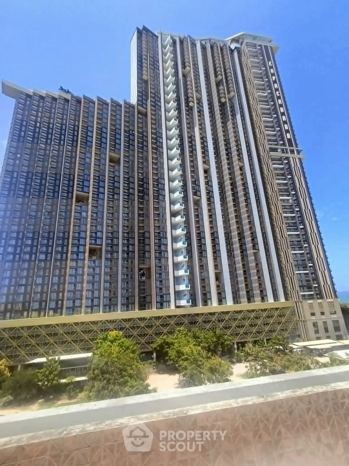 Stunning high-rise building with modern architecture and lush surroundings, perfect for luxury urban living.