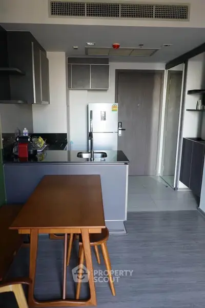 Modern kitchen with sleek cabinetry and dining area in stylish apartment