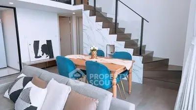 Modern living room with stylish staircase and elegant dining area