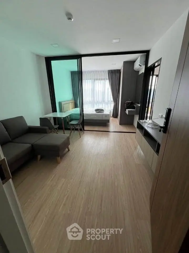 Modern apartment interior with open layout, featuring living room and bedroom with stylish decor.