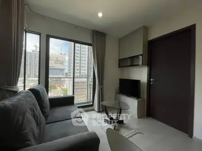 Modern living room with city view, featuring sleek furniture and large windows.