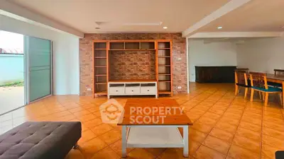 Spacious living room with brick accent wall and modern furniture, perfect for family gatherings.