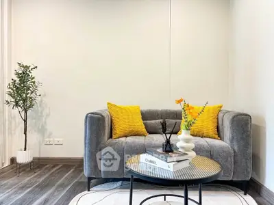 Stylish living room with modern gray sofa, vibrant yellow cushions, and chic decor accents.