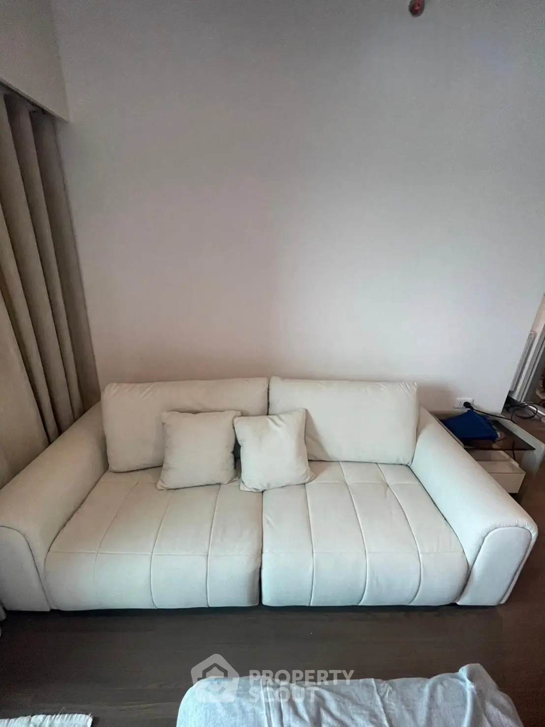 Modern living room with stylish white sofa and cozy cushions, perfect for relaxation and comfort.