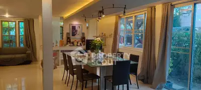 Spacious dining area with glass table and garden view, perfect for family gatherings.
