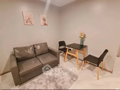 Cozy living room with modern sofa and dining set, perfect for small apartments.