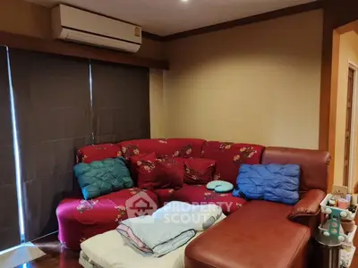 Cozy living room with red sectional sofa and air conditioning