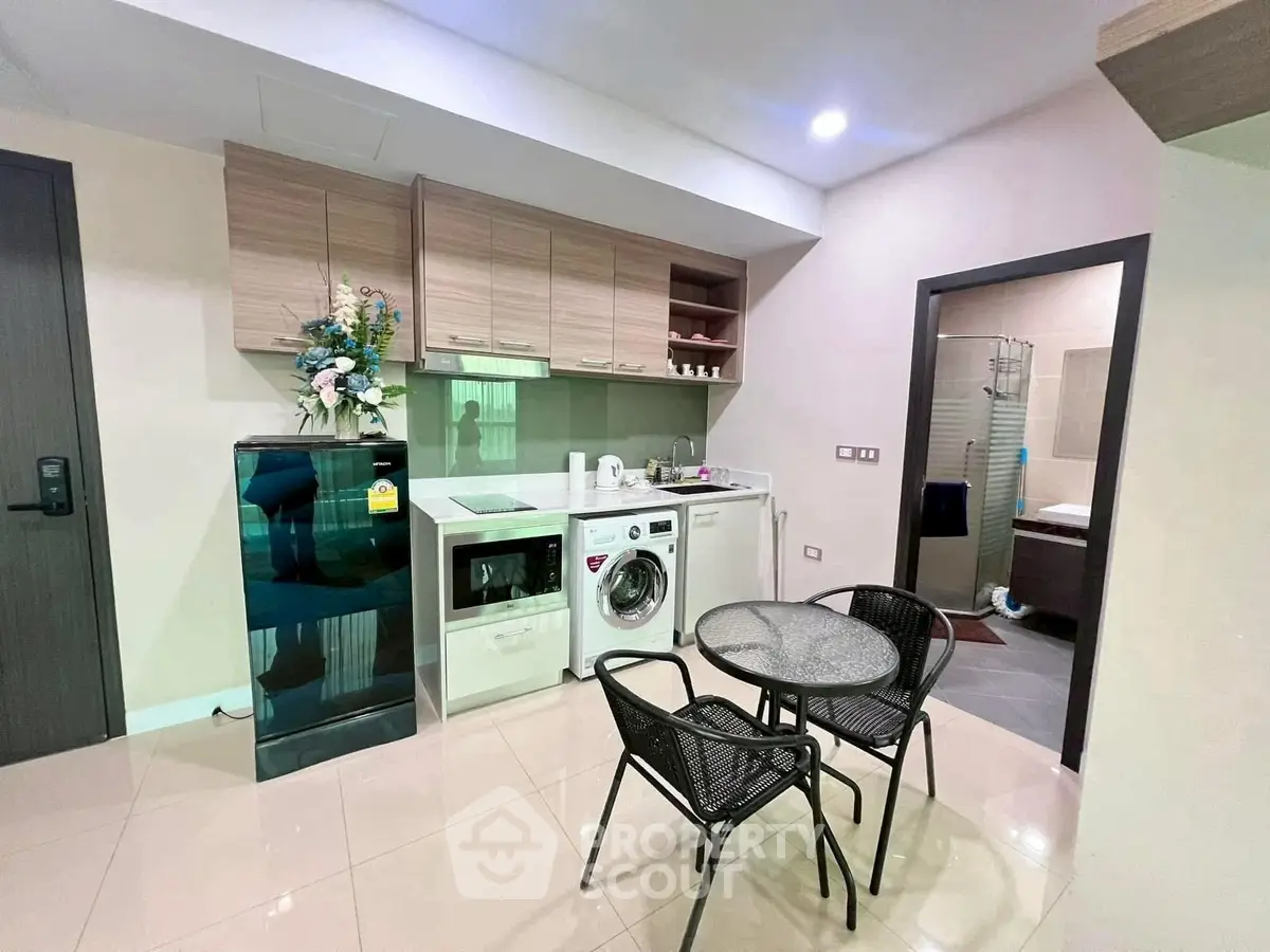 Modern kitchen with appliances and dining set in cozy apartment
