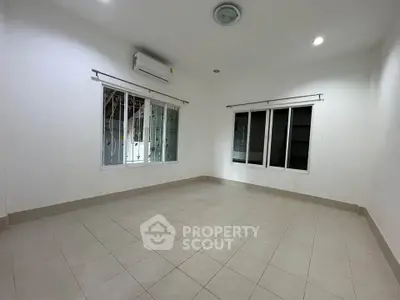 Spacious empty room with tiled floor and large windows, perfect for customization.