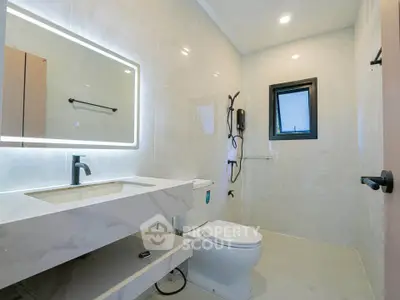Modern bathroom with sleek fixtures and illuminated mirror