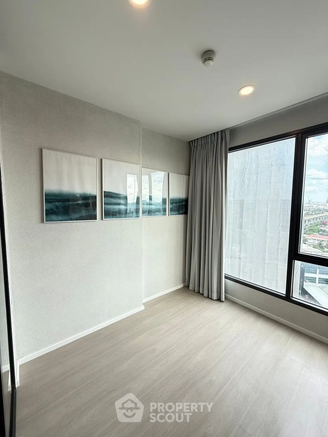 Spacious modern room with large windows offering city views, perfect for a stylish living space.