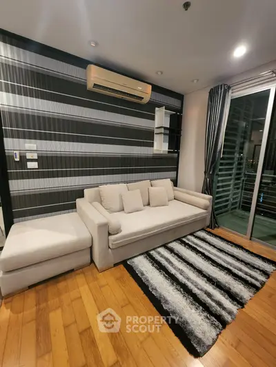 Modern living room with stylish sofa, air conditioning, and balcony access in a chic apartment.